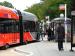 Bus Stop Change Service Request - red and grey double-length bus pulling up to a bus stop